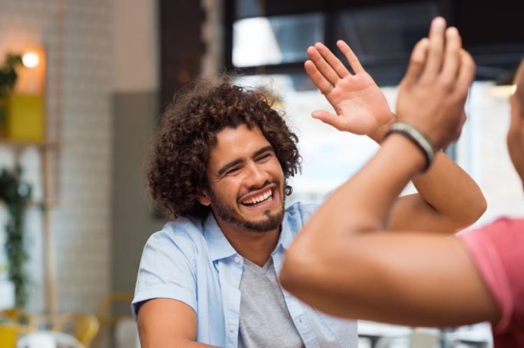 Happy man high fives friend to celebrate his sobriety