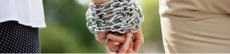 Chains are wrapped around a couple’s clasped hands