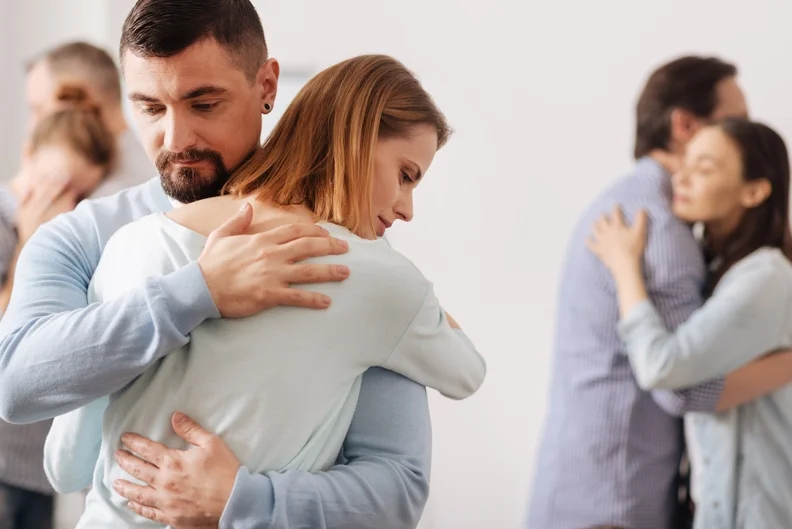 Couples in rehab embrace each other