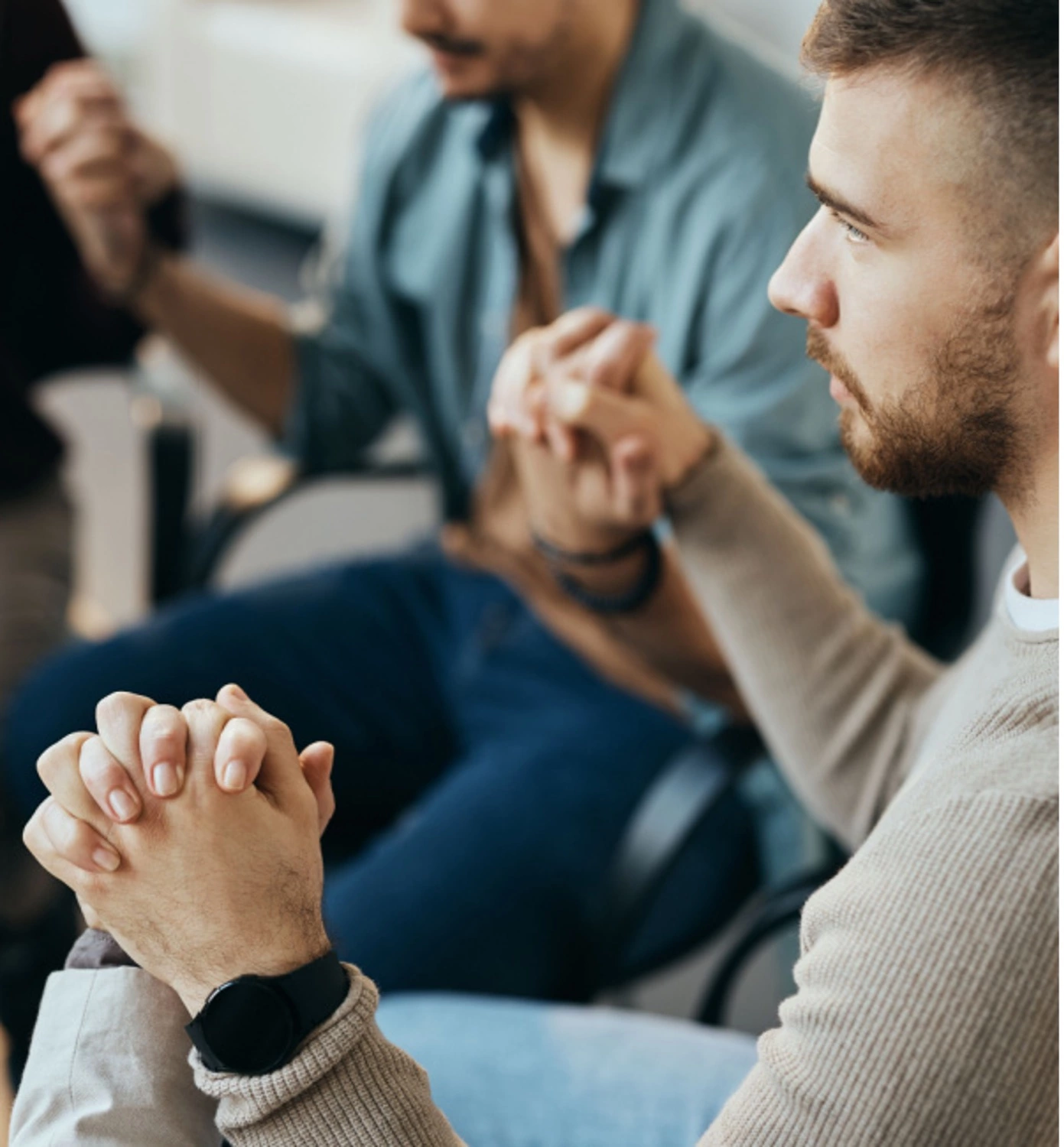 group of men holding hands for therapy session