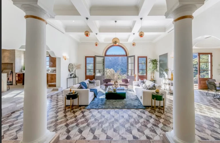 Luxurious living room with two large couches, columns, and natural views in Los Angeles rehab facility