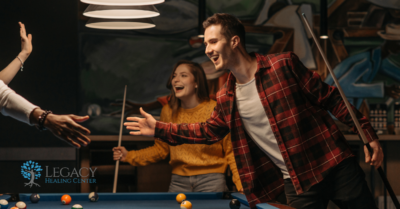 People having fun while playing pool, no alcohol in sight.